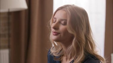 Çekici, neşeli beyaz kadın sabah yatak odasında poz veriyor mutlu kadın kameraya bakıyor sağlıklı kız modeli gülüşü sağlıklı beyaz dişli dişçi sarışın yetişkin kadın hafta sonu rahatla