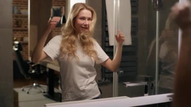 Cilveli, beyaz, güzel görünümlü, çapkın bir kadın. Aynadaki yansıma. Cilt bakımı, saç stili, rutin mutluluk, ev banyosu.