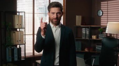 Pozitif gülümseyen iş adamı işaret parmağıyla işaret ediyor. Kafkasyalı orta yaşlı bir işadamı gibi kameraya bakıp mutlu bir şekilde işe destek olmayı seçiyorsun.