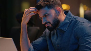 Yorgun Hintli adam iş adamı dizüstü bilgisayarda fazla mesai yapan gece vardiyasında çalışan yorgun erkek programcı sinirli erkek çalışanı baş ağrısı sorunu aşırı çalışma