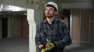 Eldivenli inşaat mühendisi Kafkasyalı mimar üniformalı ustabaşı şantiye inşaatına başla elektrikçi, tamirci, tamirci, endüstri güvenliği kuralları