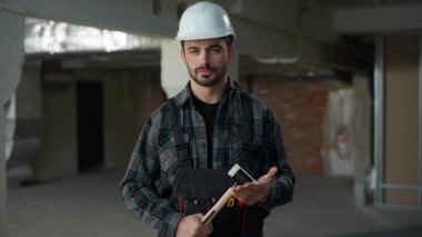 Kafkasyalı kendine güvenen beyaz adam inşaat alanında çekiç tutan inşaat mühendisi beyaz erkek tamirci mimar kameraya bakan usta ustabaşı