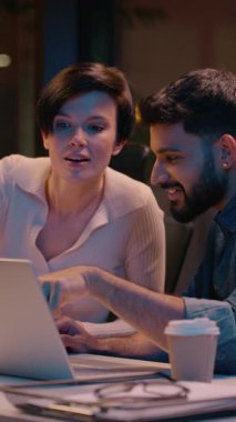 Çok ırklı iş adamı Hintli erkek Kafkasyalı kadın iş ortağı bilgisayar gece ofisindeki iş arkadaşlarına gülümseyen meslektaşlar başarılı bir iş birliği anlaşması beşliği çaktı.