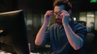 Karanlık gece ofisindeki iş adamı gözlüklü iş adamı internette çalışıyor geç saatlere kadar çalışan, gözlüklü, orta yaşlı, profesyonel bir işçi fazla görme yetisini koruyor.