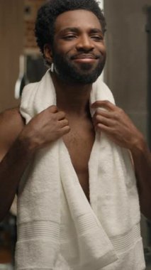 Banyoda sakallı, sakallı, aynadaki yansımaya bakan, sabah temizliği yapan, gülümseyen, nemlendirici, losyon jölesi, yumuşacık cilt kremi kullanan zenci bir adam.