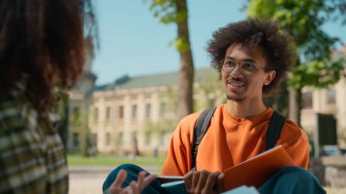 İki Afrikalı Amerikalı öğrenci takım çalışmasını birlikte öğrenmeyi konuşuyor. Kız arkadaş, erkek erkekle birlikte şehir dışında üniversite akademisi kampüsünde çalışıyor.