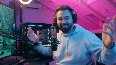 Beyaz tenli gülümseyen mikrofon kameraman erkek oyuncu flamalı flama etkili blogcu kulaklık kayıt kanalı online vlog sohbet e-spor video oyunu siber spor radyo sunucusu