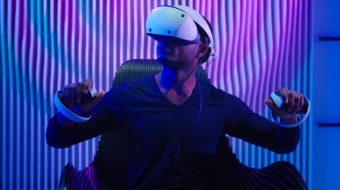 Afrikalı Amerikalı erkek oyuncu erkek oyuncu oyun oynuyor sanal gerçeklik gözlüğü takıyor üç boyutlu oyun kaskı modern siber teknoloji neon fütürizm menekşe odası fütüristik meta evren oyun yazılımı
