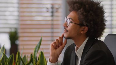 Düşünceli, Afrikalı, Amerikalı, düşünceli, erkek iş adamı, şirkette yaratıcı iş adamı. Düşünceler zor bir başlangıç arar. Ofisin tereddütlerini çözer.