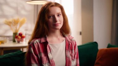 Kafkasyalı genç kız gülümseyen neşeli duygusal yüz gülen, gülen, gülen, kaygısız, mutlu, mutlu bir kadın. Oturma odasında oturmuş kameranın sağlıklı diş şakasına bakan, esprili bir bayan.