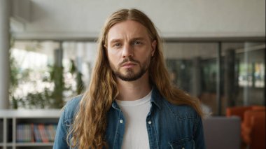 Kafkasyalı, düşünceli, düşünceli, düşünceli, ciddi bir yüz ifadesi takınan üniversite portresindeki kameraya bakan beyaz bir erkek.