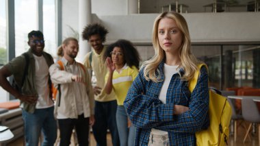 Üniversite koleji kabadayılığı. Çok ırklı dört çoklu etnik öğrenciyle alay eden kötü zorba alay ediyor. Üzgün, yalnız, beyaz kadın çalışmasını işaret ederek alay ediyorlar.