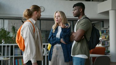 Bir grup farklı üniversite arkadaşı üniversite koridorunda üç çok ırklı öğrenci buluşması Kafkasyalı kadın hayal kırıklığına uğramış Afrikalı Amerikalı erkekler çok kültürlü dostluk konuşmalarını destekliyor.