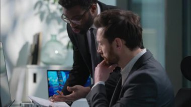 İki çok ırklı iş adamı Kafkasyalı Afrikalı Afrikalı Amerikalı adam bilgisayar danışmanlığını işaret ederek proje hakkında konuşuyorlar takım çalışması iş arkadaşları ofis online iş arkadaşları çeşitli arkadaşlar tavsiyesi