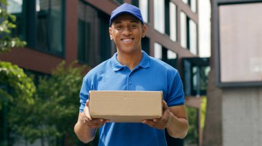 Portre mutlu bir şekilde gülümsüyor. Afro-Amerikan kuryeye bakıyor. Erkek teslimatçı teslimatçı.