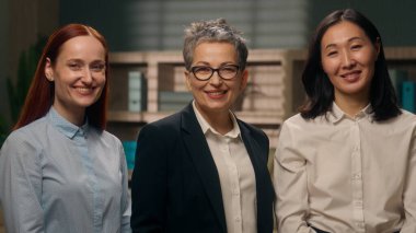 Çok uluslu kadın ofis portresi kameraya bakıyor başarılı iş arkadaşları gülümsüyor bayanlar iş adamları iş adamları iş adamları profesyonel şirket çalışanları birlikte