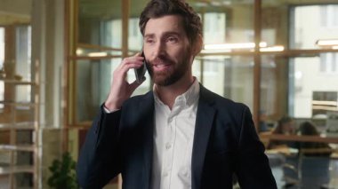 Ofiste cep telefonundan konuşan beyaz iş adamı gülümseyen iş adamı cep telefonuyla konuşan orta yaşlı erkek yönetici konuşması akıllı telefondan profesyonel konuşma danışmanı.