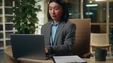 Çok görevli Asyalı Koreli iş kadını, dizüstü bilgisayarda çalışan iş kadını, cep telefonuyla konuşan bir kadın müşteriyle görüşüyor. Gazeteleri kontrol ediyor.