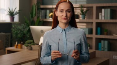 Beyaz tenli, güler yüzlü, öğretmen, iş kadını, gözlüklü, stil sahibi, iş kadını, mutlu, kameraya bakan bir kız.