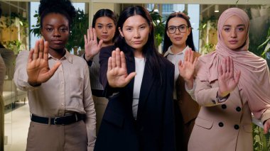 Ciddi çeşitlilikteki çok ırklı kadın iş arkadaşları kız arkadaşlar iş arkadaşları kameraya bakan beş iş kadını el hareketi işareti gösteriyorlar.