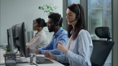 Çevrimiçi bilgisayar ofisi müşteri hizmetleri çağrı merkezinde çalışan çok ırklı yardım hattı çalışanları. Çeşitli gülümseyen Kafkas Hintli Afrikalı kadınlar. Kulaklık takmış adam, müşterilerine iş hakkında bilgi veriyor.
