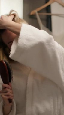 Kafkasyalı mutlu bir kadın saç fırçası şarkısı söylüyor banyoda eğleniyor neşeli bir kadın model şarkı söylüyor mikrofon dansı yapıyor karaoke duşu yapan sıradan bir kız banyoda saç fırçalamaktan zevk alıyor