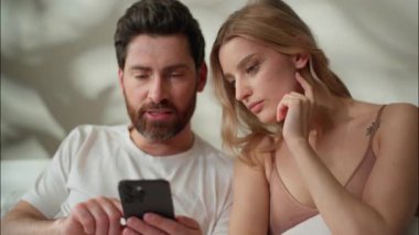 Beyaz aile tipi cep telefonu tipi sabahları birlikte ev partnerleri eşleri ile birlikte akıllı telefon oyunu oynayan kadın internet bağlantısı kullanarak kocalarıyla konuşuyorlar.