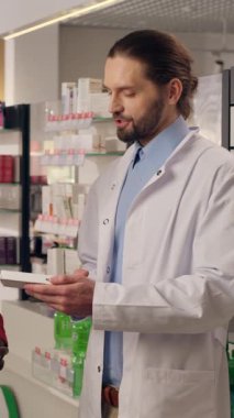 Tıbbi danışmanlık doktoru eczacı, eczane sağlık hizmetlerinde ilaç hapları alan müşterilere yardım ediyor. Farmakoloji reçeteli Afrikalı Kafkasyalı çok ırklı erkeklerin el sıkışmasına yardımcı oluyor.