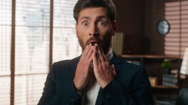 Kafkasyalı orta yaşlı iş adamı yetişkin işadamı, işveren erkek işadamı ofiste şaşkın şaşkın şaşkın büyük gözleri kapalı elle ağzı kapalı kameraya bakarken inanılmaz bir teklif