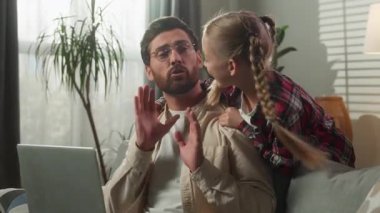 Kafkas aile problemi, konsantre olmuş baba evde dizüstü bilgisayar başında çalışırken, kız gürültücü çocuk, yaramaz çocuk, titreyen baba sinirli çocuk, gücenmiş kız.