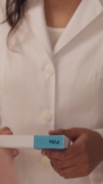 Hintli kadın eczacı eczanedeki müşterilere danışmanlık yaparak ilaç siparişi, tavsiye sağlık sorunu, kadın sağlık hizmetleri ilaçlarının satın alınmasına yardımcı oluyor.