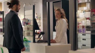 Eczanede beyaz adamın ilaçlarına yardım eden eczacı kadın baş ağrısı tavsiyesi, tıbbi uzman müşteri danışmanı, eczane sağlık ilaçlarında konuşan doktor.