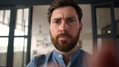 Web kamerasının bakış açısı, cep telefonu ekranında yazı yazan beyaz bir adamın babasının sosyal medyada sohbet etmesinden rahatsız olmuş.