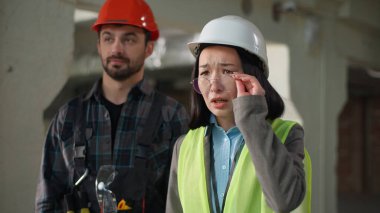 İnşaatçılar, çok ırklı iş adamları, Japon müfettiş, kötü proje başarısızlıkla sonuçlandı. Asyalı kadın başlığını çıkardı. Gözlük mühendisleri, beyaz adamın sorun inşaatı hakkında konuştuğunu söyledi.