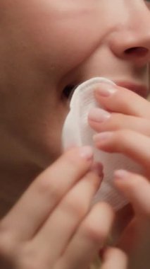 Pamuk sünger kullanarak mutlu kadın modelini kapat. Ruj temizleme makyajını sil. Ağızdan beyaz, sağlıklı kadın derisini çıkar.