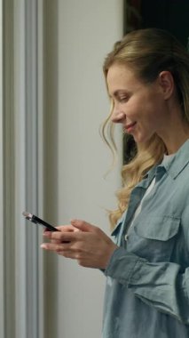 Mutlu kadın müşteri cep telefonu kullanıyor. Pencere daktilo kullanıyor. Beyaz tenli müşteri müşterisi. Kadın iş kadını, sohbet ediyor.