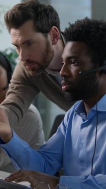 Çağrı Merkezi Kafkasyalı iş adamları Afrikalı işçi bilgisayar daktilo desteği hakkında açıklama yapıyor. Kulaklık takmış Hintli kadın. Çağrı merkezinde çalışan çoklu etnik operatörler, ofiste ticaret yardım hattı satıyorlar.