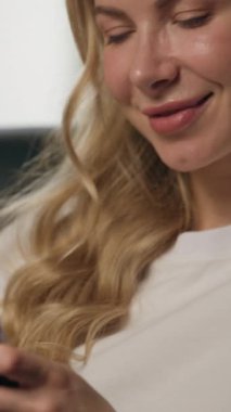 Gülümseyen kadın müşterinin cep telefonunu açıp SMS yazarken mutlu iş kadını e-iş kadını akıllı telefon uygulaması online iletişim bağlantısı kullanarak apartmanda sosyal medya sohbeti yapıyor.