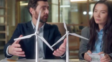 Yel değirmenleri sunan çok ırklı iş arkadaşlarıyla görüşmeler ekoloji yeşil enerji kaynağı çevre Kafkasyalı iş adamı elini sıkın Koreli yatırımcı para yatırım bürosuna verdi