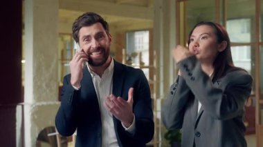 Endişeli çoklu etnik çeşitliliğe sahip iş kadını cep telefonlarıyla konuşuyor. Stres ofisinden bağırıyor, Koreli iş kadını Kafkasyalı işadamının üstünü değiştiriyor. Akıllı telefonlara müşteri anlaşması yapıyor.