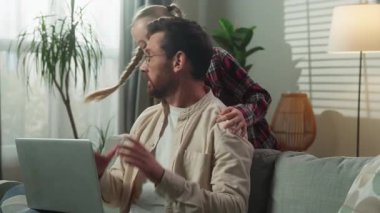 Stresli baba dizüstü bilgisayarda uzaktan kumandayla çalışıyor enerjik kız dikkat çekmek için çabalıyor baba sinirli çocuk kız, kötü ebeveyn stresli aile.