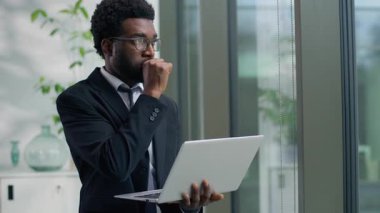 Afrika kökenli Amerikalı dalgın iş adamını kapat. Bilgisayarda sohbet et. İnternette yazma sorunu çöz.