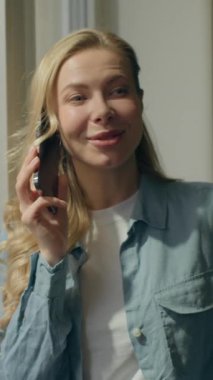 Kafkasyalı mutlu iş kadını konuşuyor akıllı telefonlu ofis penceresine bak ev manzaralı bayan işkadını müşterisi serbest çalışan cep telefonu siparişi veriyor.