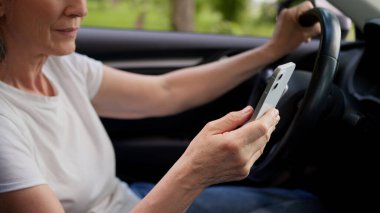 Bilinmeyen Kafkasyalı yaşlı kadın olgun yaşlı sürücü emekli araba sahibi elektrikli otomobil daktilo mesajını cep telefonlu akıllı telefon konuşmaları sosyal medya uygulaması iletişimi kullanarak kapatıyor.