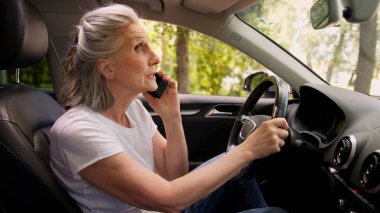 Kafası karışmış, Kafası karışmış, yaşlı, yaşlı, yaşlı, yaşlı bir kadın olgun araba sürücüsü, araba sahibi, büyükannesi otomobil ulaşımında cep telefonuyla konuşan, akıllı telefonlardan konuşan, şehirdeki GPS 'i kaybetmiş.