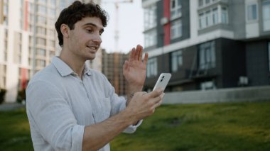 Kafkasyalı bir adam cep telefonuyla konuşuyor. Akıllı telefon görüşmeleri online video toplantısı konferansı, blogcu girişimci erkek iş adamı Vlogger kentinin dışındaki sanal sohbet şehri.
