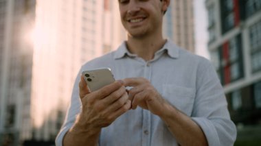 Kafkasyalı bir adam cep telefonu akıllı sosyal medya kullanıyor. Gülümsüyor, tokalaşıyor, mutlu bir erkek. İnternet üzerinden iş dünyası uygulaması ile sohbet ediyor.