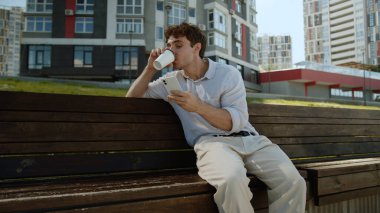 Kafkasyalı bir adam cep telefonuyla kahve içiyor akıllı cep telefonu online çalışan girişimci internet sosyal medya komik gülüşlü iş adamı erkek iş adamı şehir yöneticisi adam açık havada eğleniyor