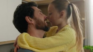 Mutfakta mutlu bir aile, sevgi dolu bir adam, evlat edinilmiş güzel bir kız çocuğu kucağında çocuk kucaklayan bir kız, birbirlerine sarılıyorlar sevgi dolu bir aşk kucaklaşması, oynaşmalar.