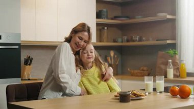 Mutfakta beyaz bir aile var. Evlatlık, mutlu, küçük bir kız çocuğu. Anne ve bebek bakıcısı.